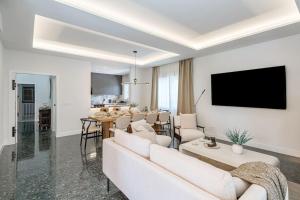 ein Wohnzimmer mit einem Sofa und einem TV in der Unterkunft Chalet de lujo 'LA CASA DE INÉS' in Alcalá de Henares