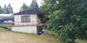 a small house with a porch and a tree at Kemp a Loděnice Podolsko - Chata in Podolí