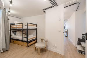 Pokój z 2 łóżkami piętrowymi i krzesłem w obiekcie Chalet de lujo 'LA CASA DE INÉS' w mieście Alcalá de Henares