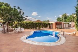 una piscina en un patio con mesa y sillas en Chalet de lujo 'LA CASA DE INÉS' en Alcalá de Henares