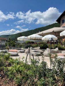 une terrasse avec des parasols blancs, des chaises et des tables dans l'établissement Hôtel Beauregard, The Originals Relais (Inter-Hotel), à Sévrier