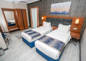イスタンブールにあるThe Bostancı Otelのベッド2台とデスクが備わるホテルルームです。