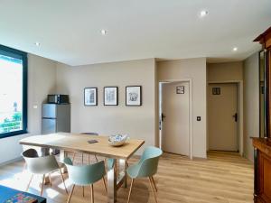 a dining room with a wooden table and chairs at Le Five Tellier - Forest in Reims