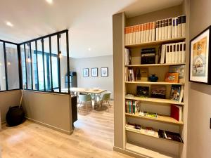 um quarto com uma estante de livros e uma sala de jantar em Le Five Tellier - Forest em Reims