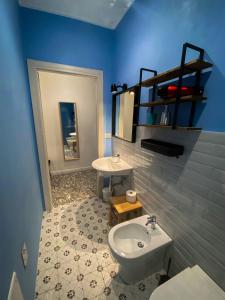 Baño azul con lavabo y aseo en Taffetà b&b, en Crispiano