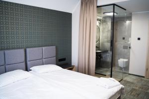 1 dormitorio con cama blanca y ducha en BULVAR en Malbork