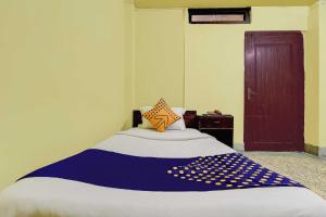 a bedroom with a bed with a blue and white blanket at SPOT ON Durba 2 in Tezpur