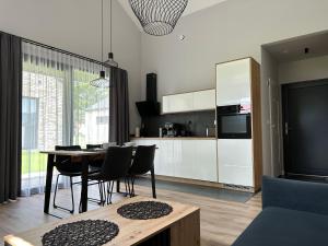 a kitchen and living room with a table and chairs at Domki Zdrojowe in Polanica-Zdrój