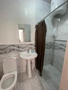 a bathroom with a toilet and a sink at Тумар in Osh