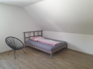 1 dormitorio pequeño con 1 cama y 1 silla en Sonnenparkhaus, en Roth