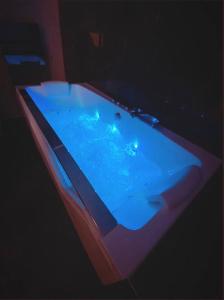 - un bain à remous avec des lumières bleues dans la chambre dans l'établissement Le Foyer d'Or - Hypercentre & Confort, à Agen