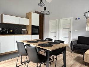 a kitchen with a table and chairs in a room at Domki Zdrojowe in Polanica-Zdrój +15 photos