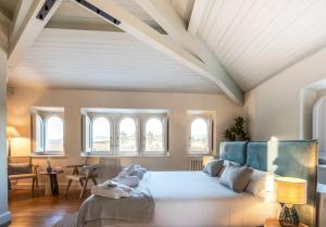 1 dormitorio con 1 cama grande en una habitaci&oacute;n con ventanas en Hotel Font de la Canya, en Avinyonet