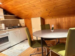 eine Küche mit einem Tisch und Stühlen im Zimmer in der Unterkunft Alpina Appartment 2 in Kandersteg