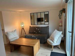 a living room with a couch and a coffee table at Logement avec piscine privée chauffée in Biarritz