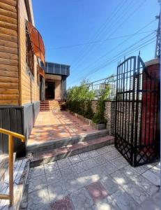 a house with a gate and a walkway next to a building at Тумар in Osh