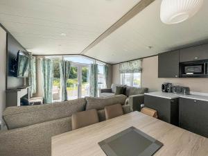 - un salon avec un canapé et une table dans l'établissement Beautiful Caravan With Decking At Carlton Meres Park, Suffolk Ref 60009cl, à Saxmundham