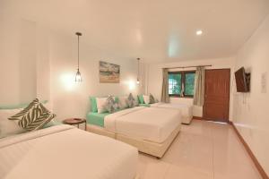 une chambre d'hôtel avec deux lits et un canapé dans l'établissement P.U. Inn Resort, à Phra Nakhon Si Ayutthaya