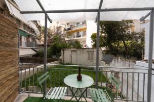 een tafel en stoelen op het balkon van een gebouw bij Neos_kosmos_house in Athene