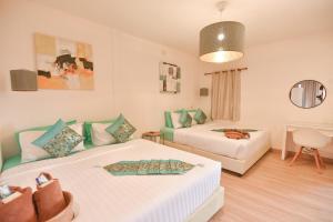 Habitación de hotel con 2 camas y mesa en P.U. Inn Resort en Phra Nakhon Si Ayutthaya