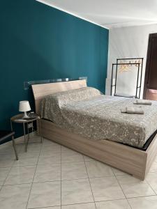 een slaapkamer met een bed en een blauwe muur bij San Damiano Inn in Catania