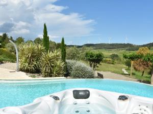 d'une baignoire installée à côté de la piscine. dans l'établissement Villa with heated pool jacuzzi sports field and stunning views, à Montbrun-des-Corbières