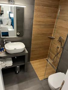 a bathroom with a shower and a toilet and a sink at Ocean Blue Suites in Ierissos