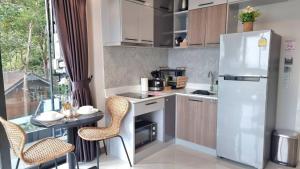 a kitchen with a refrigerator and a table and chairs at Bo304-Panorama Seaview 1 Bedroom at Ao Nang Beach in Ao Nang Beach