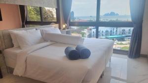 a bedroom with a white bed with two blue towels on it at Bo304-Panorama Seaview 1 Bedroom at Ao Nang Beach in Ao Nang Beach