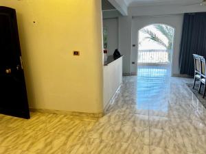 a living room with a yellow wall and wooden floors at Full Moon House in Luxor