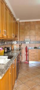 a kitchen with wooden cabinets and a counter top at Tavira Pimpão - Sea View Flat in Tavira