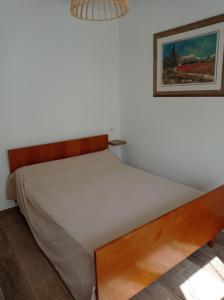 1 cama en una habitación con una foto en la pared en LA MAISON DE PAPOU La Vigne A NANS LES PINS 83860, en Nans-les-Pins