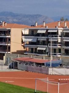 a tennis court in front of a large building at Sofias Home in Nafplio