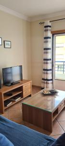 uma sala de estar com uma televisão e uma mesa de centro em Tavira Pimpão - Sea View Flat em Tavira