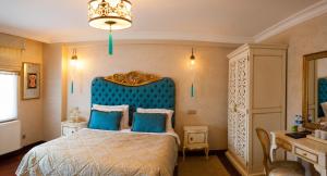 a bedroom with a blue bed with a blue headboard at İstanbul Bosphorus Hotel Symbola in Istanbul