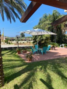 a patio with two chairs and an umbrella at Villa Piruzzu CV Torre Mulinazzo app P in Cinisi