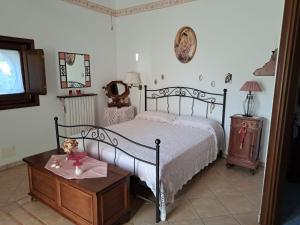 a bedroom with a bed and a table and a tv at La Casa Di Lidia in Cardile