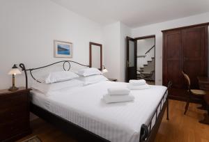 a bedroom with a large white bed with two towels on it at Heritage house Dvor in Sutivan +10 photos