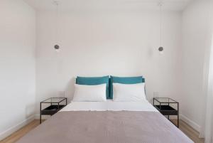 - un lit blanc avec 2 oreillers et des têtes de lit bleues dans l'établissement Attico 70 - Puteoli Apartament, à Pouzzoles