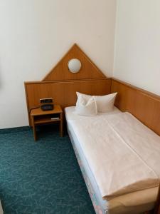a hotel room with a bed and a table at Hotel Garni Eschenbach in Hildburghausen