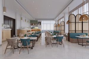Season Inn Hotel_Al Hail في سيب: تقديم مطعم بالطاولات والكراسي