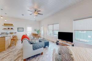 a living room with a couch and a flat screen tv at The Yellow Rose in Gulf Shores