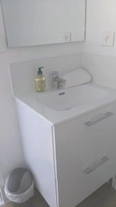 - un lavabo blanc dans la salle de bains avec un distributeur de savon dans l'établissement Appartements au Cœur de Maine, à Angers