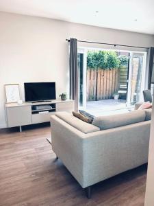 a living room with a couch and a television at The Bank's Lodge by ZILT in Limmen