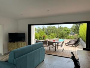 uma sala de estar com um sofá azul e uma mesa com cadeiras em Residence Mare e Monte em Favone