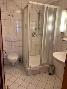 ein Bad mit einer Dusche und einem WC in der Unterkunft Hotel Garni Eschenbach in Hildburghausen