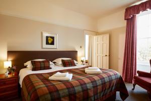 a bedroom with a bed with two towels on it at Macdonald Plas Talgarth Resort in Pennal