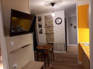 a kitchen with a table and a clock on the wall at La Grelauderie 6 in Saintes