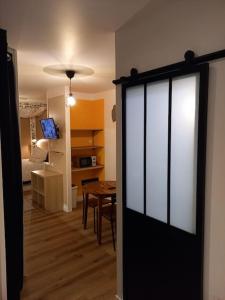 Una puerta a una habitación con una mesa y un dormitorio en La Grelauderie 6, en Saintes