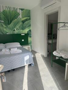 a bedroom with a bed and a green leafy wall at B&B Villa Fabrizia in Diamante